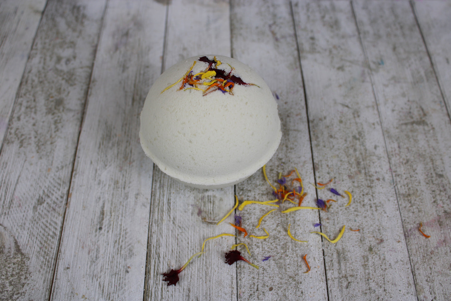 One of the Cocoa Butter bath bombs with botanicals spread around. 
