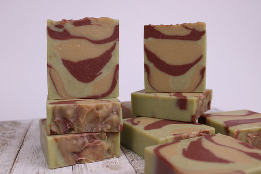 The Lemongrass soaps in this photo have an arrayed lying flat with a few stacked on them.  We were trying to show the colors from different angles in this photo. The dark redish burnt color of the rhassoul clay. It really shows the color in this. You can see the light yellow and light green contrast that burnt red really well.